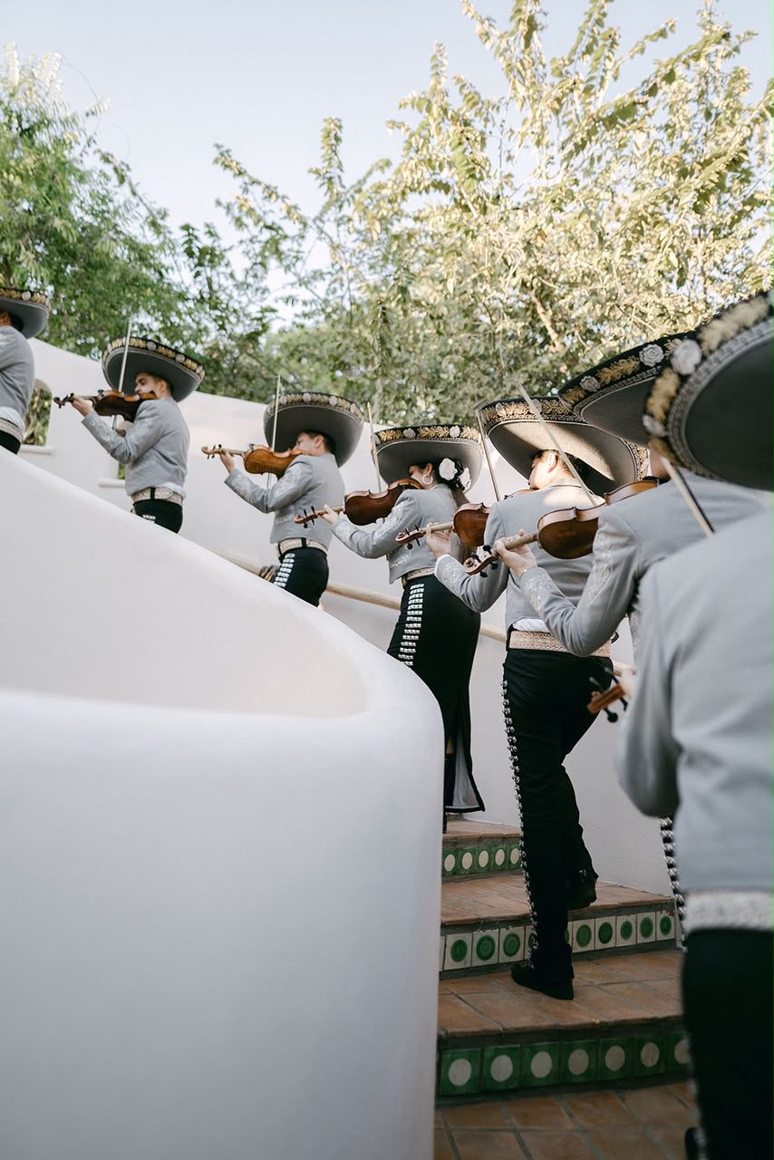 El mariachi sube la escalera tocando los violines