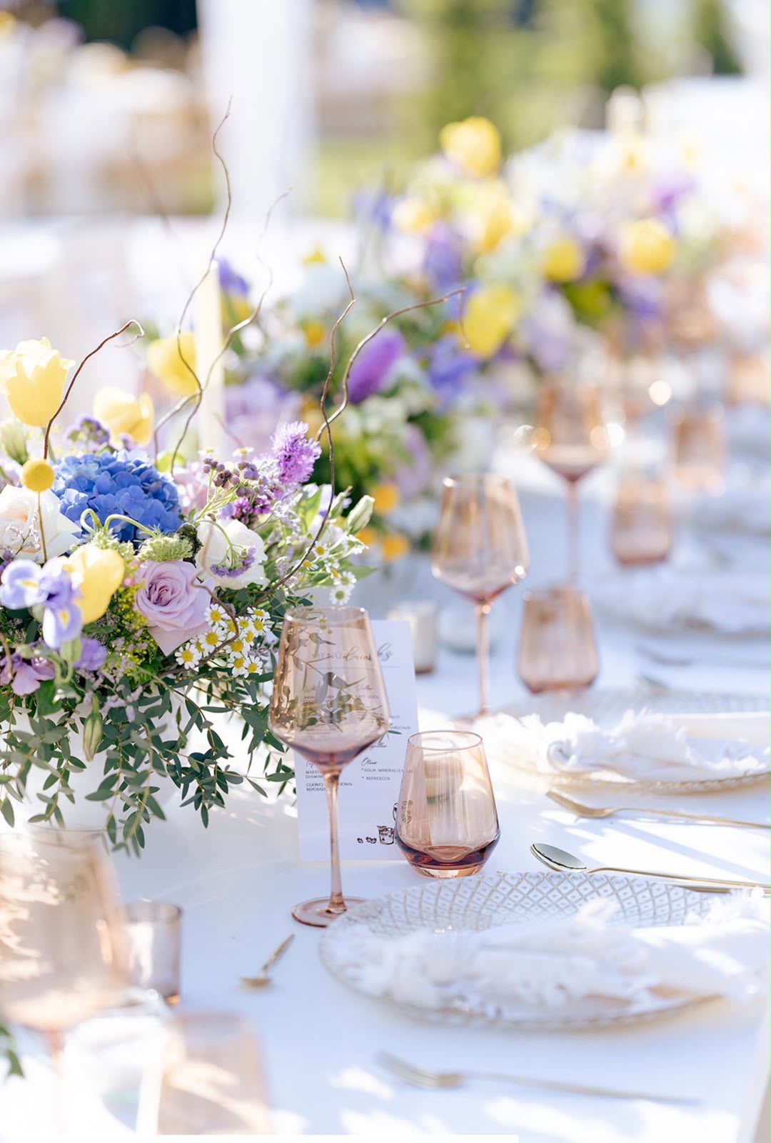 Centro de mesa con tulipanes amarillos, hortensias azules y rosas malva
