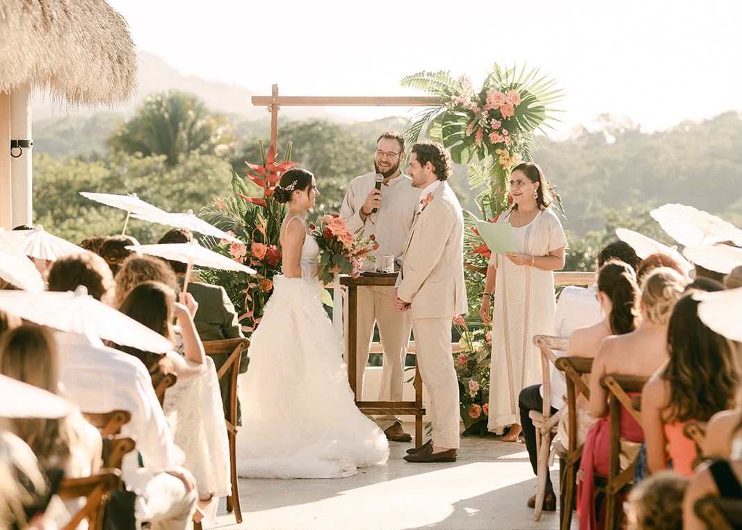 La ceremonia en una terraza frente a la selva, con los invitados bajo sombrillas de papel